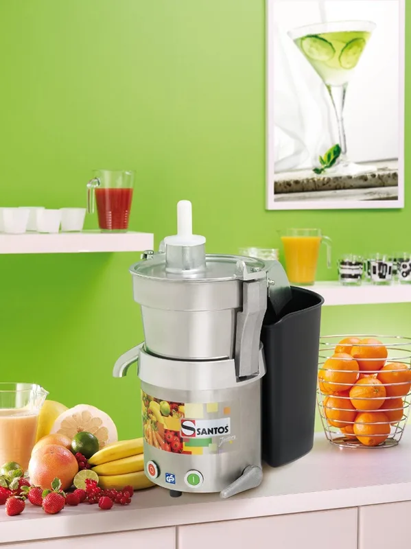 „Santos“ #28 centrifugal juicer on a counter with fruit and jugs of juice