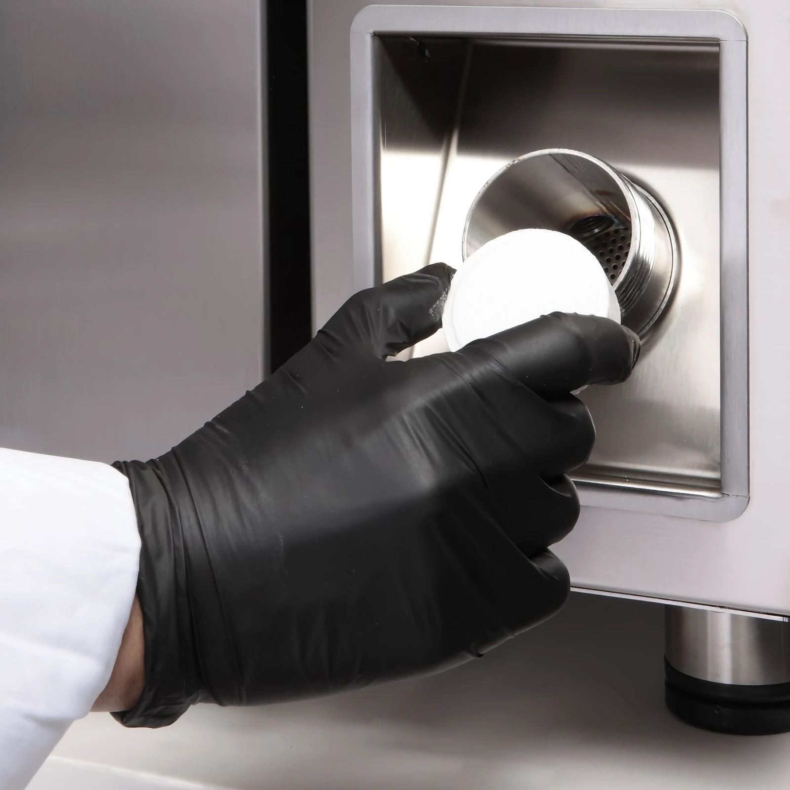 A detergent tablet being placed in the tablet holder below the control panel of an „Inoxtrend“ oven