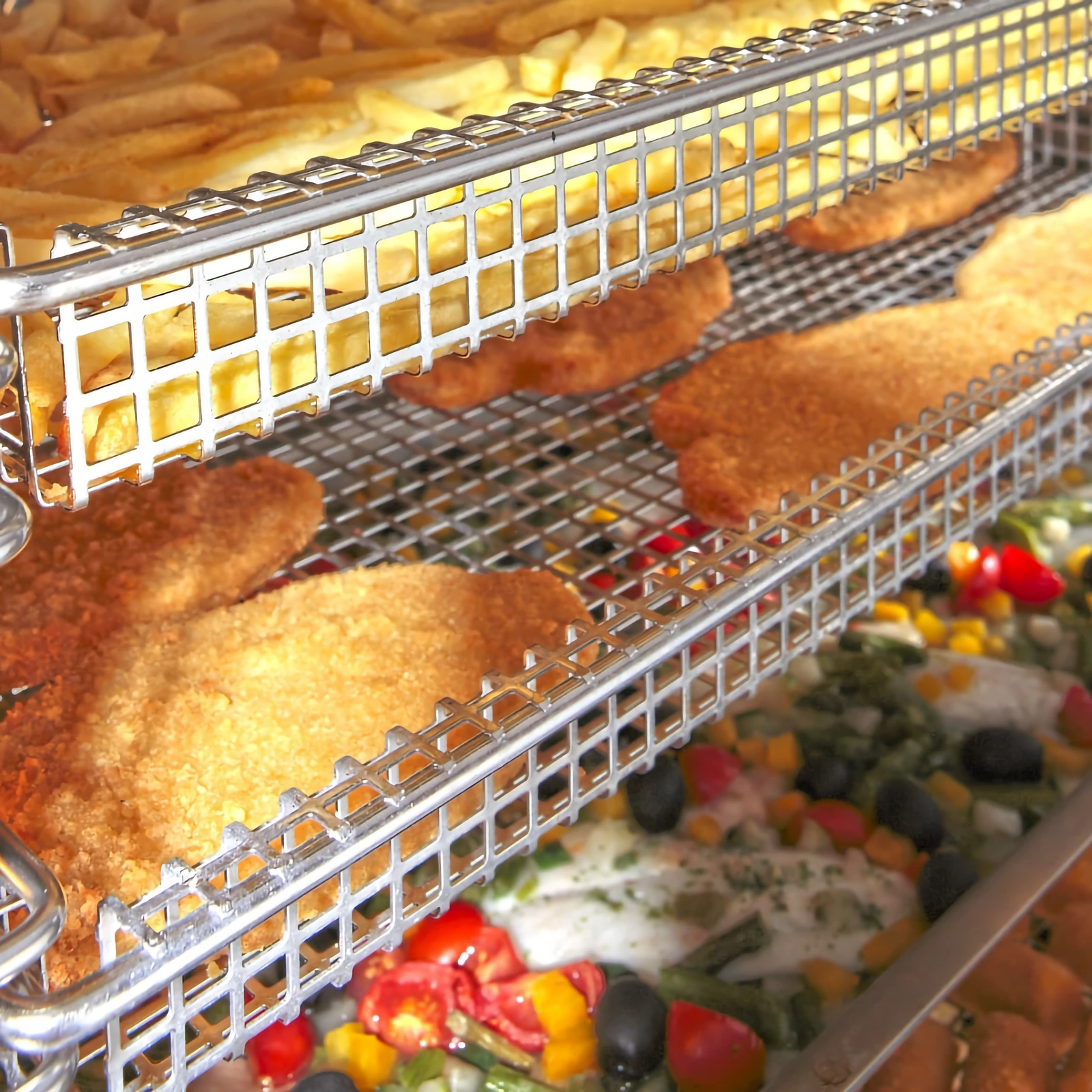 Manufacturer photo: schnitzels, chips and vegetables cooking on several levels of an „Inoxtrend“ oven